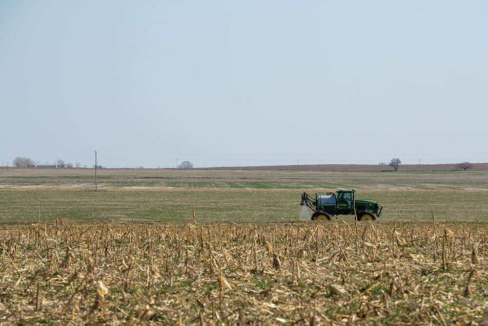 Tractor applying fertilizer to a field