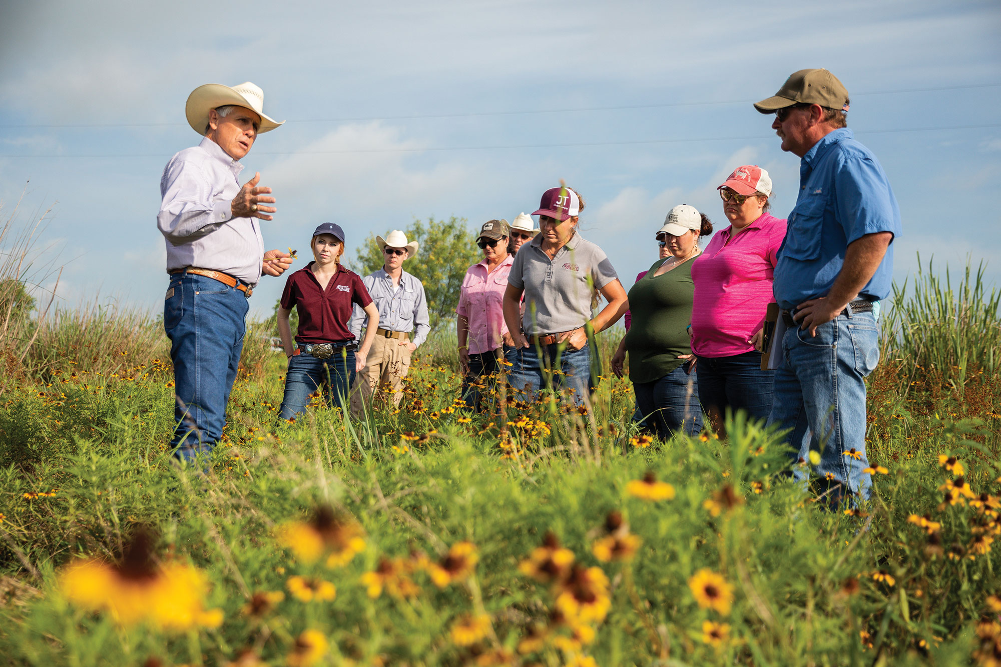 Gary Price (left) discusses soil microbes, water quality and broader beef industry challenges with county extension agents during a tour of his ranch.