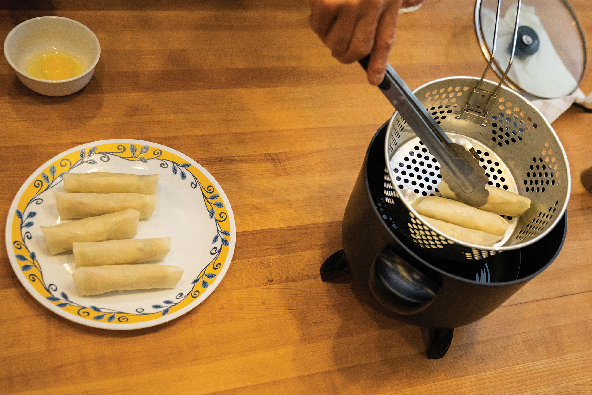 Placing egg rolls into the fryer