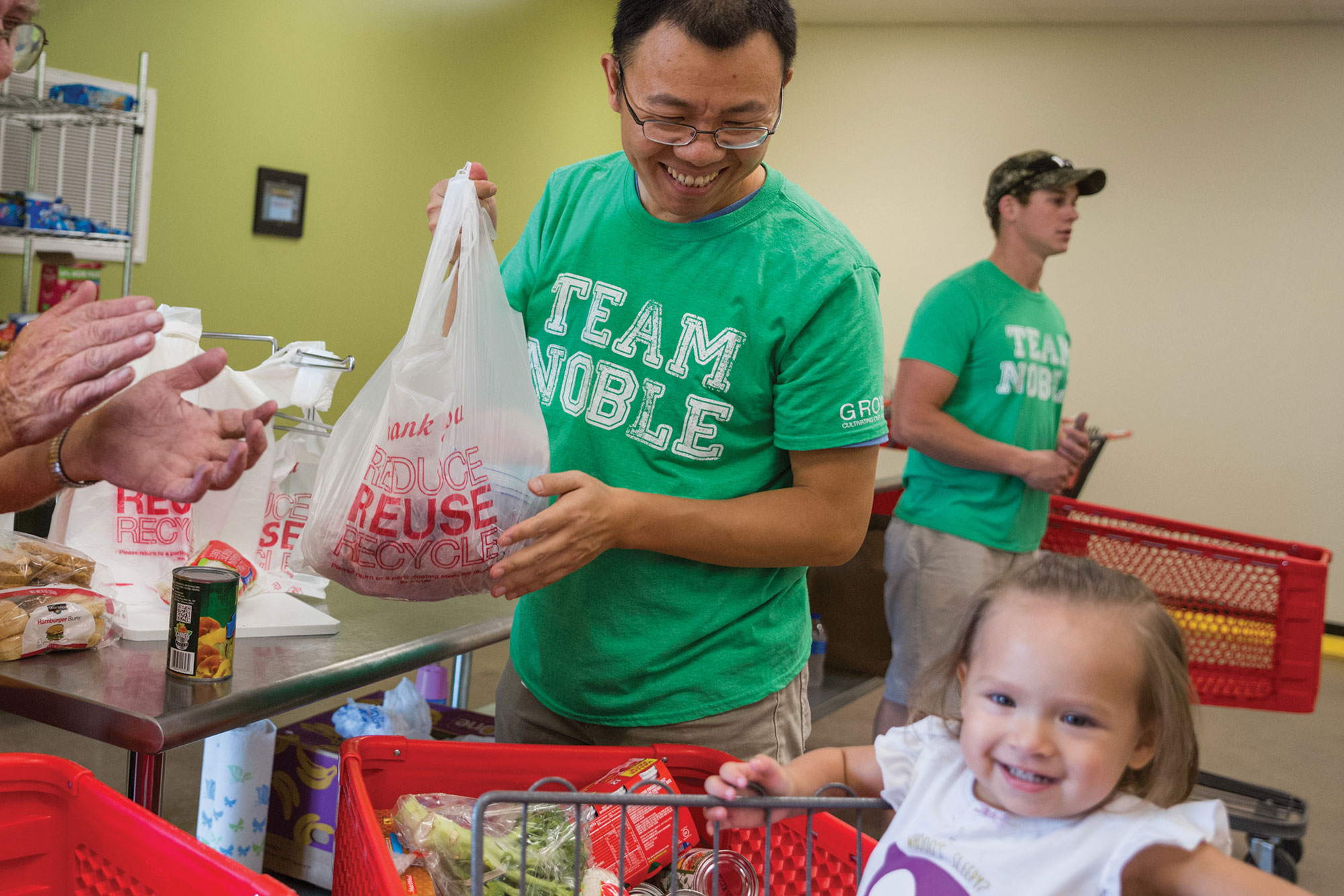 Maofeng Chai, Ph.D. and Landon Riggle help families shop and bag their food selections to take home.