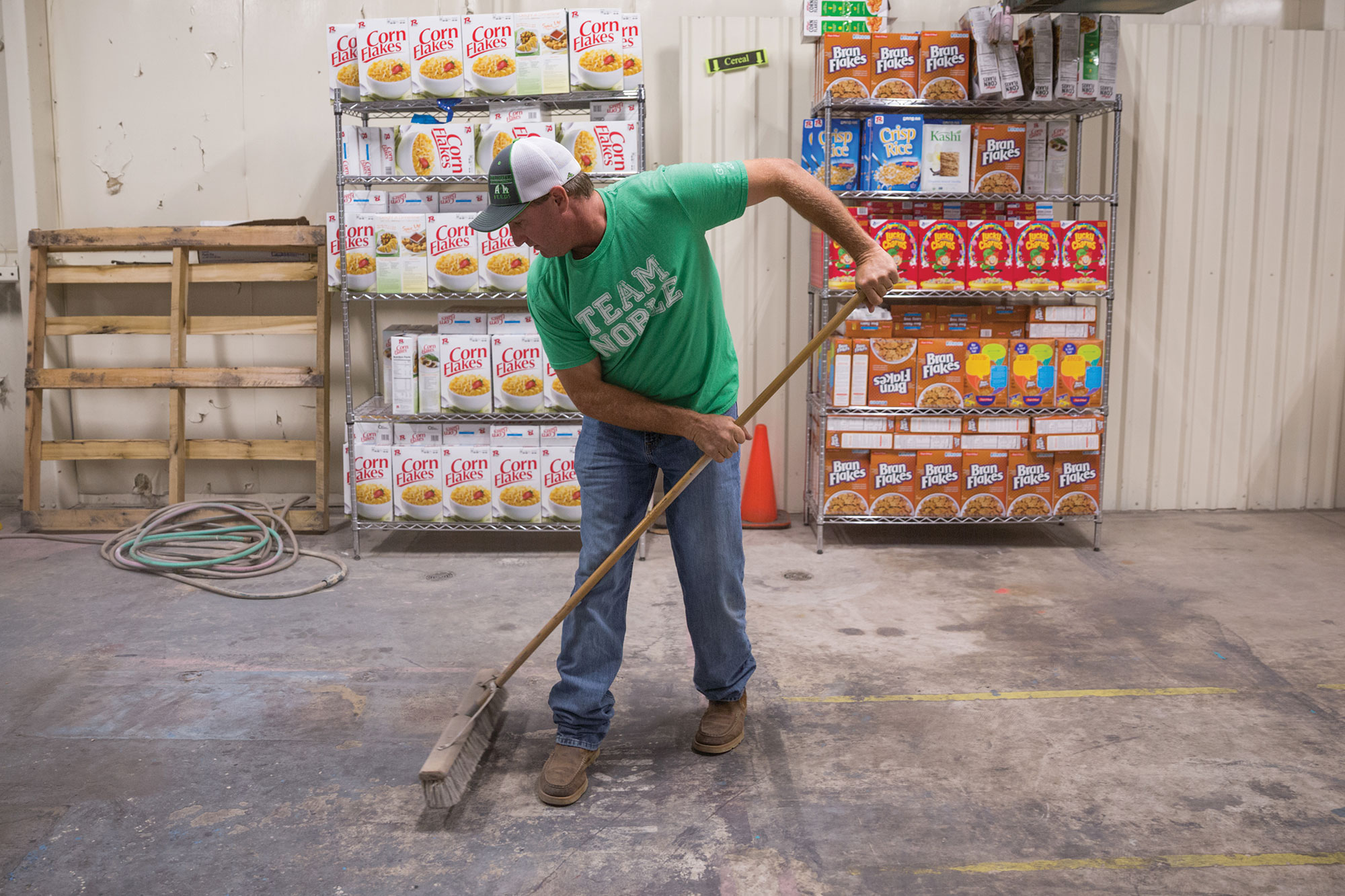 Ronald Trett sweeping the warehouse.