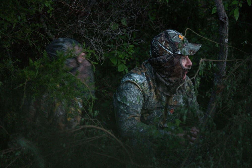 Hunters hiding in woods in full camoflage waiting for a deer