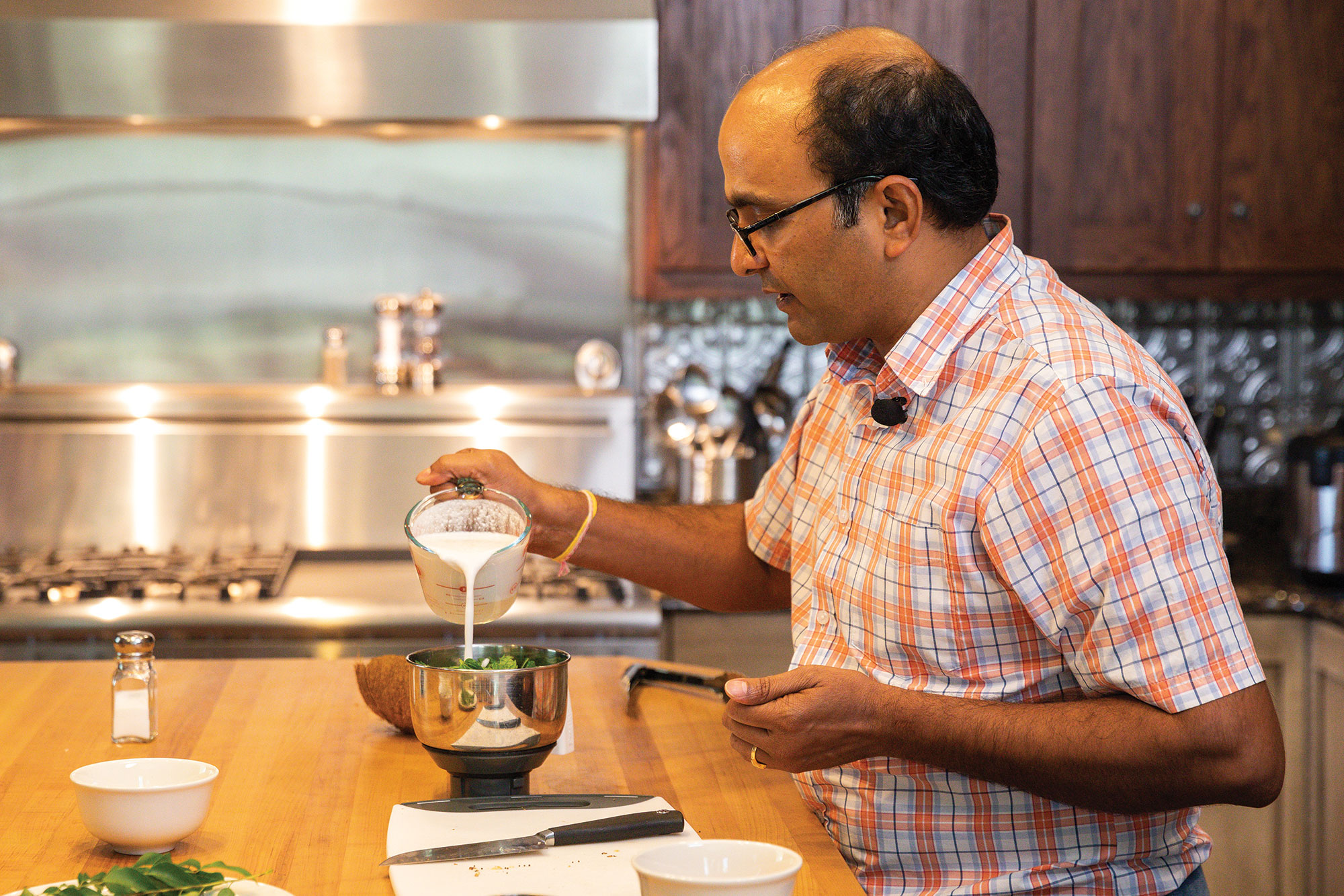 Suresh Bhamidimarri, Ph.D. pours coconut milk into bowl with other ingredients