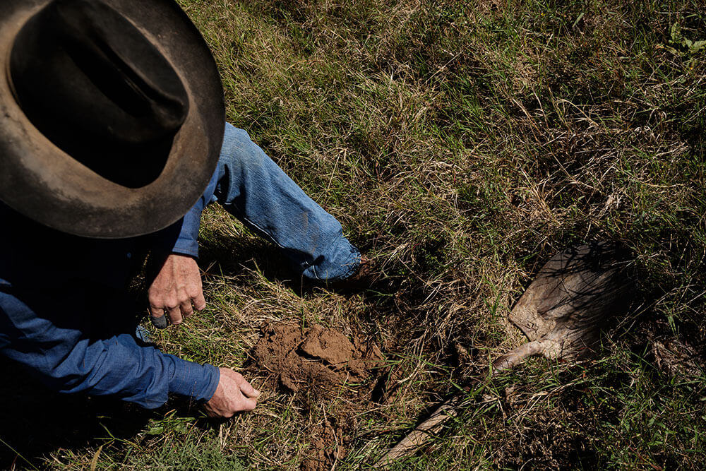 Rancher inspects soil