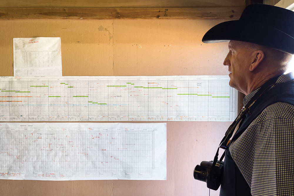 Visitor to Noble examines grazing plans hanging on wall of facility