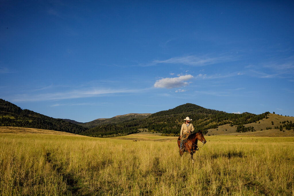 man rides his horse on ranch